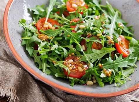 Diätmenü. vegane küche. gesunder salat mit rucola, tomaten und pinienkernen. | Kostenlose Foto