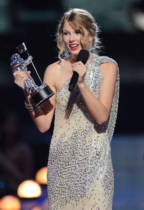 taylor swift accepts an award for her performance in the movie's musical, american idol