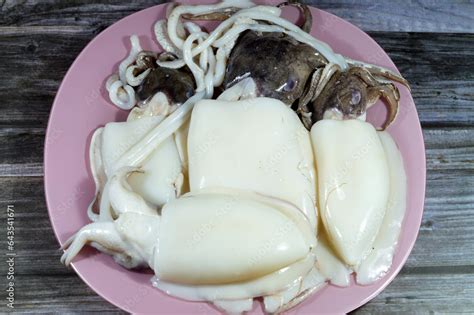 Fresh raw uncooked squid, a mollusc with an elongated soft body, large eyes, eight arms, and two ...