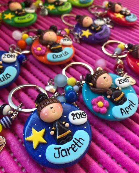 many different key chains are laying on a pink surface with name tags attached to them