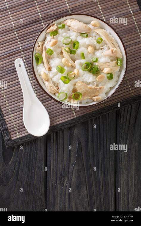 Ginger chicken Jook Rice Porridge close-up in a bowl on the table. Vertical top view from above ...