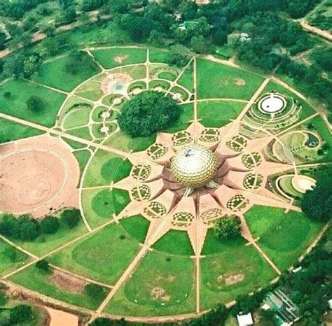 an aerial view of a circular structure in the middle of a field with trees and grass