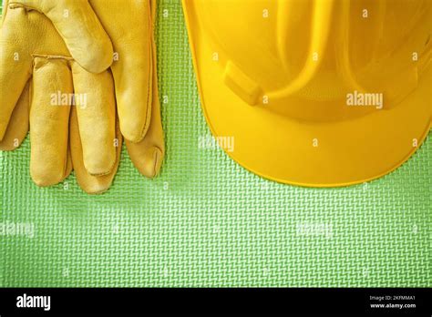 Yellow hard hat protective gloves on green background construction concept Stock Photo - Alamy
