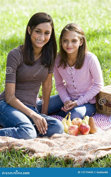 Girls Sitting On Picnic Blanket On Grass In Park Stock Image - Image of ...