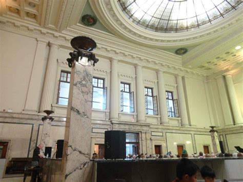 people are sitting at tables in an old building with domed ceilings and marble columns,