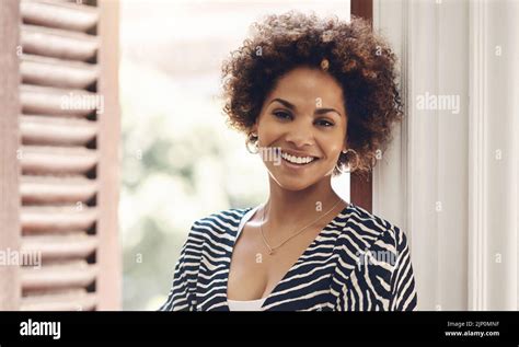 Beautiful, happy and edgy african woman smiling and showing a positive attitude while standing ...