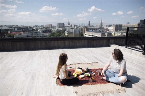 Woman with below-elbow amputation and girl having a healthy meal on the roof stock photo