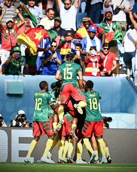 a group of soccer players huddle together on the field in front of an audience