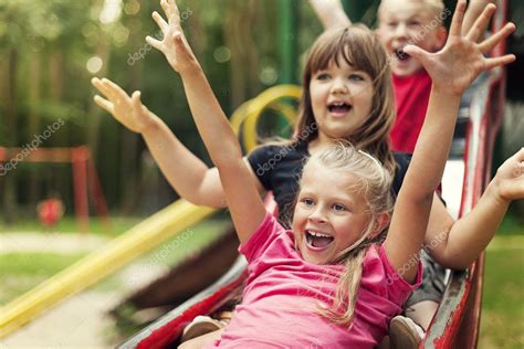 niños felices jugando en diapositiva — Foto de stock © gpointstudio ...