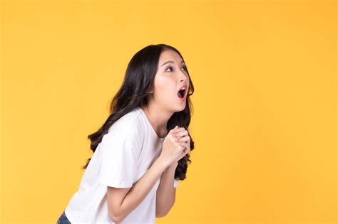 Image of feeling excited, shock, surprise and happy. Young asian woman standing on yellow ...