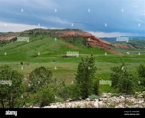 Red sandstone cliff and rolling grassy plains from the Chief Joseph Scenic Highway, Wyoming, USA ...