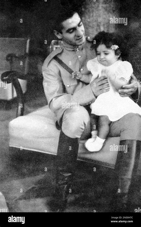 The young Shah of Iran, Mohammad Riza Pahlavi, with his little one-year-old daughter, Princess ...