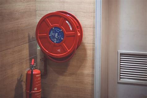 Red Fire Extinguisher Beside Hose Reel Inside the Room · Free Stock Photo