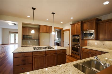 a kitchen with wooden cabinets and marble counter tops