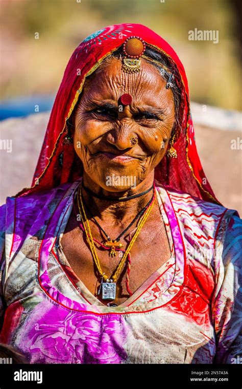 Colourfully dressed desert dwellers, mud hut settlement in the Thar ...