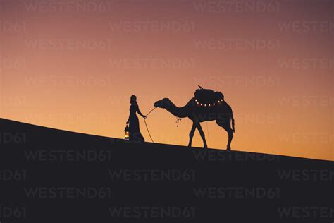 Silhouette woman with camel walking at Sahara Desert against clear sky ...