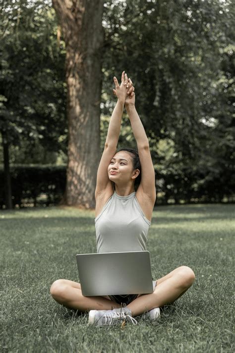 Cheerful woman stretching arms during online studies · Free Stock Photo