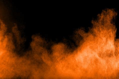 Premium Photo | Abstract orange powder explosion on black background.