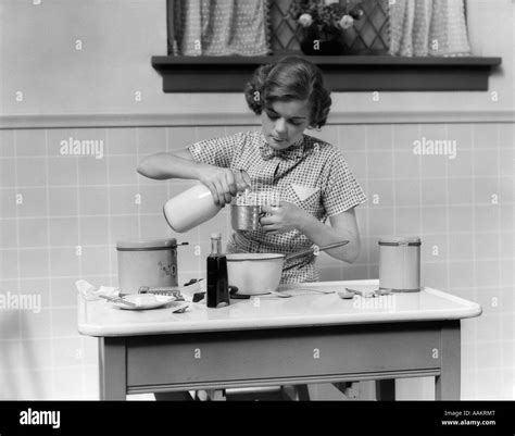 Young girl pouring glass milk Black and White Stock Photos & Images - Alamy
