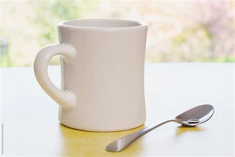 "Retro Coffee Mug And Spoon On Diner Counter Near Window" by Stocksy Contributor "David Smart ...
