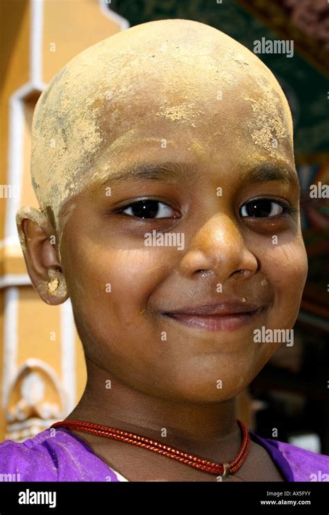 Young hindu girl has freshly shaven head covered in sandalwood for the goddess Mariamma ( Kali ...