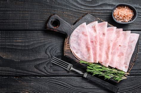 Premium Photo | Sliced prosciutto ham on wooden cutting board. black wooden background. top view ...