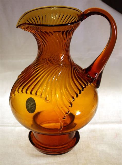 a yellow glass pitcher sitting on top of a table