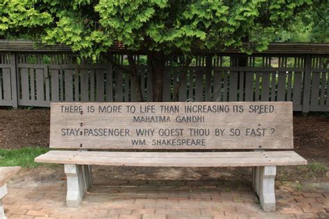 A Park Bench with a Engraved Quotes by Mahatma Gandhi and William Shakespeare on a Brick Pathway ...