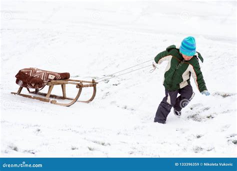 Boy pulling sled on snow stock image. Image of playing - 133396359