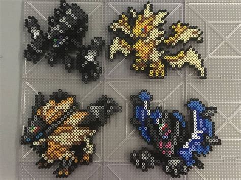 four pixellated images of different types of pokemons on a white surface with grey squares