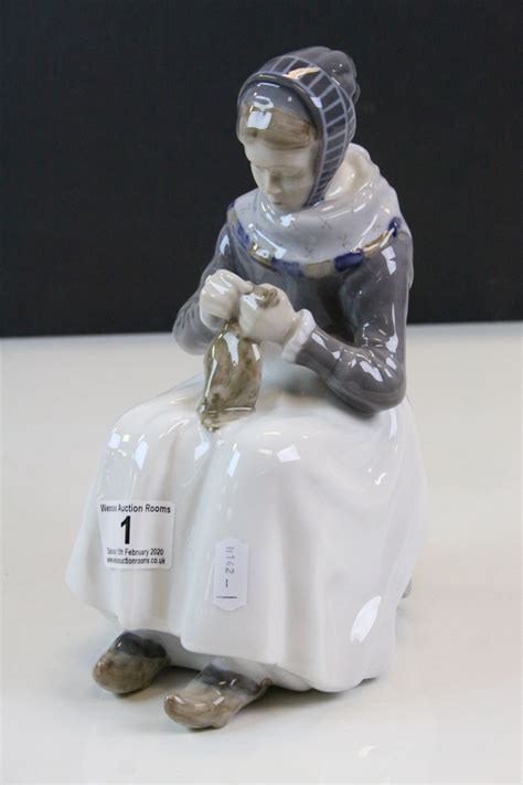 Royal Copenhagen figurine of a seated Female wearing Clogs and Sewing, numbered 1317 to base & st