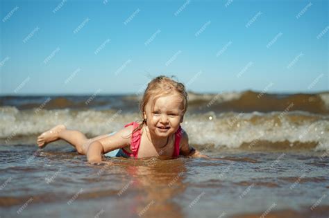 Premium Photo | Little girl lying in sea in waves