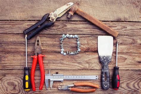 Construction tools in the form of house on wooden background. | Hearts of Mercy