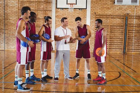 Coach interacting with basketball players Stock Photo | Adobe Stock