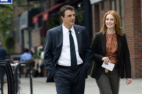 a man and woman are walking down the street together, both dressed in business attire