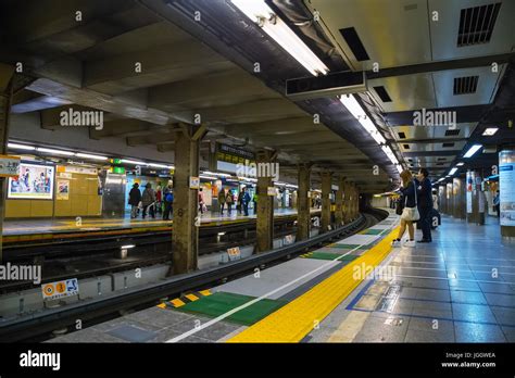 Japanese subway commuter wait for a train in a Tokyo Metro subway ...