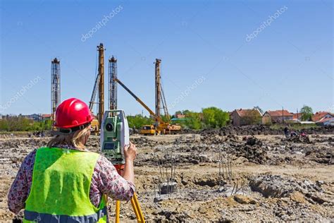 Female geodesist is working with total station on a building sit Stock ...