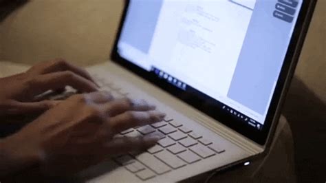 a person typing on a laptop with their hands