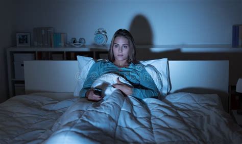 Woman watching tv in bed stock image. Image of film - 178083935