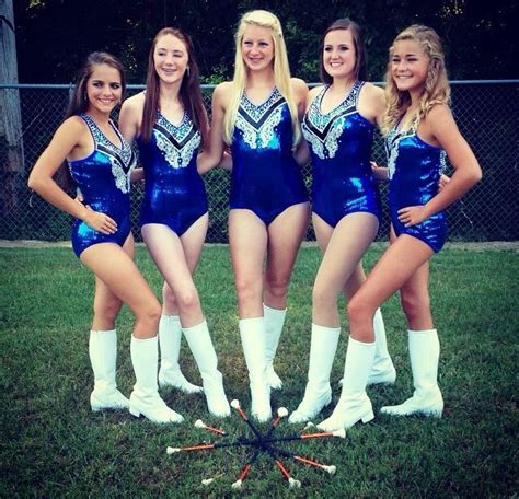 four cheerleaders are posing for a photo in their blue leotards uniforms