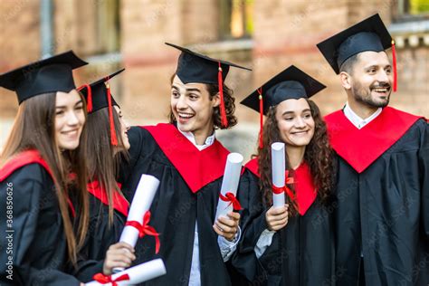 Graduates embrace, enjoy and look at the camera on the graduation ...