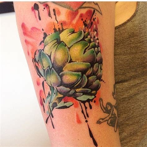 a woman with a tattoo on her arm has an artichoke design on it