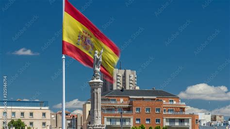 Spanish flag waves behind statue of Christopher Columbus timelapse ...