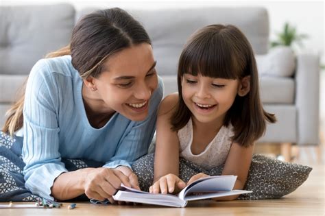 Mother and daughter lying on warm floor reading book - CHEC