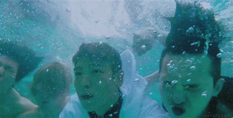 three men are under water with their mouths open