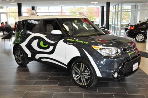 a black and white car with green eyes on it's side in a showroom