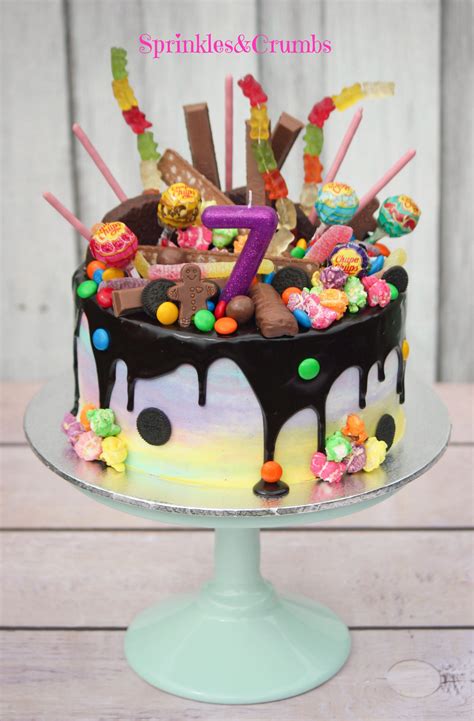 Rainbow candy drip cake pale frosting paired with crazy toppings ...