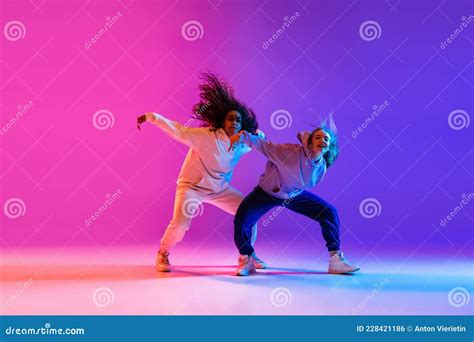 Two Beautiful Active Hip-hop Girls Dancing on Gradient Pink Purple Neon ...