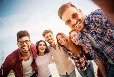 Group of young people having fun outdoors on the beach Stock Photo | Adobe Stock