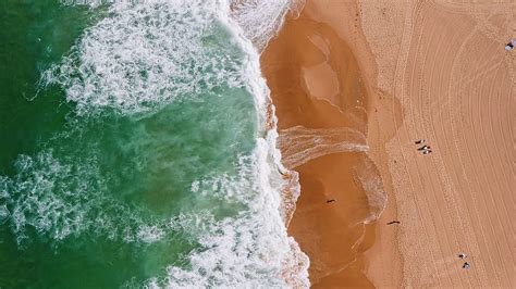 Top aerial view of waves break on tropical yellow sand beach. Bird's ...